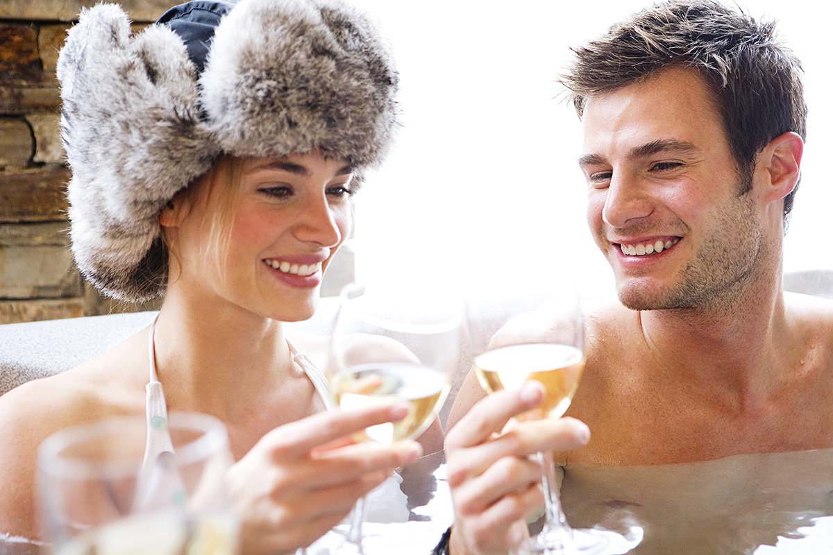 young couple après-ski champagne in hot tub